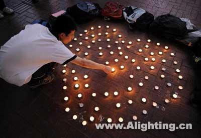 学生点燃摆成心形的烛灯哀悼地震遇难者